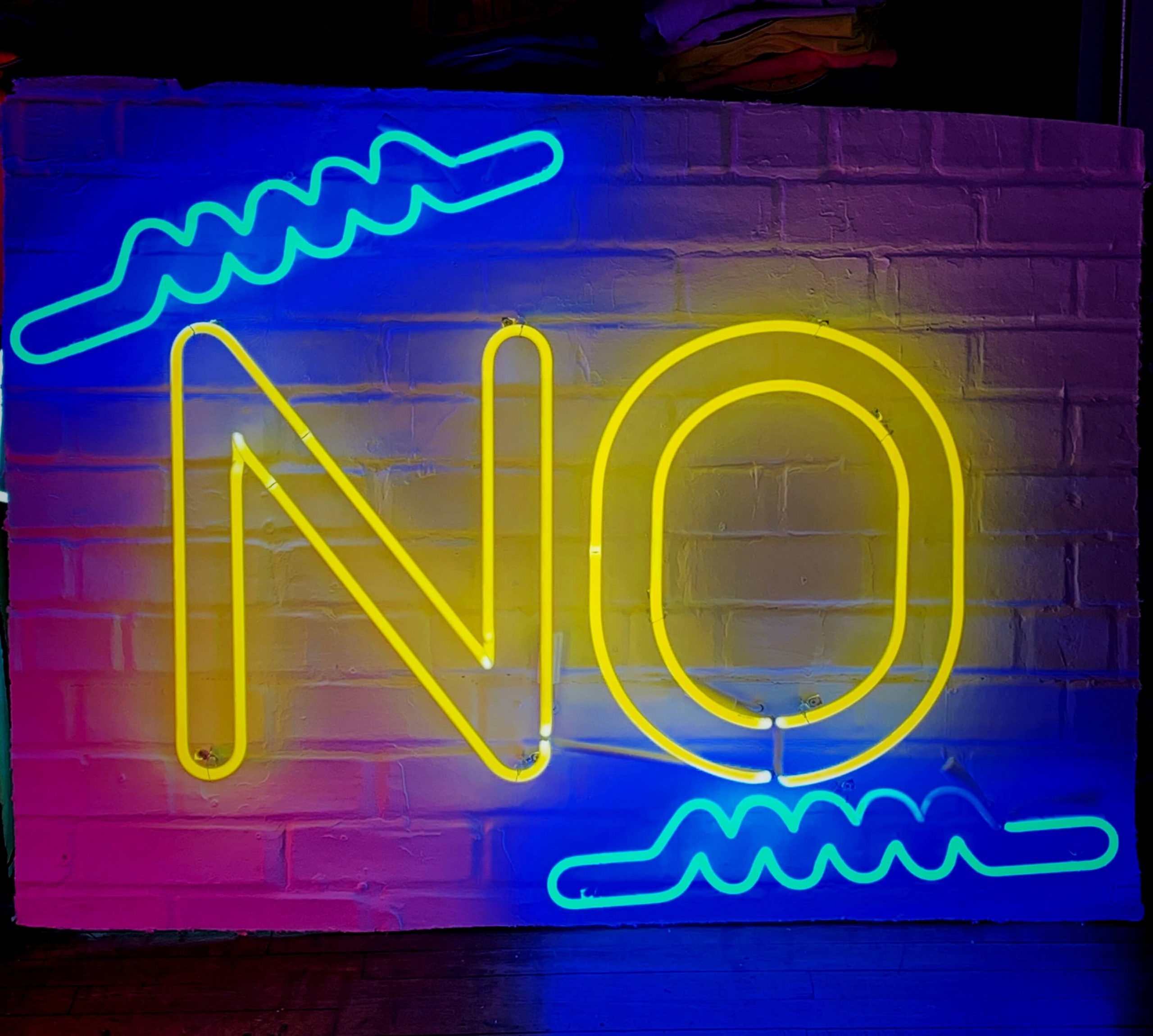 A neon sign in the shape of the word "NO" in yellow and blue.
